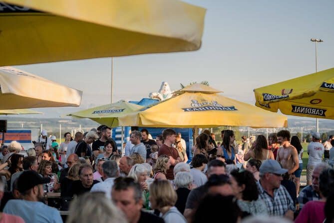 Leute sitzend und stehend im Biergarten and den Beachgames